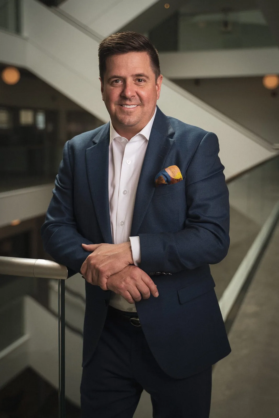 Corporate headshot of a businessman in a navy suit