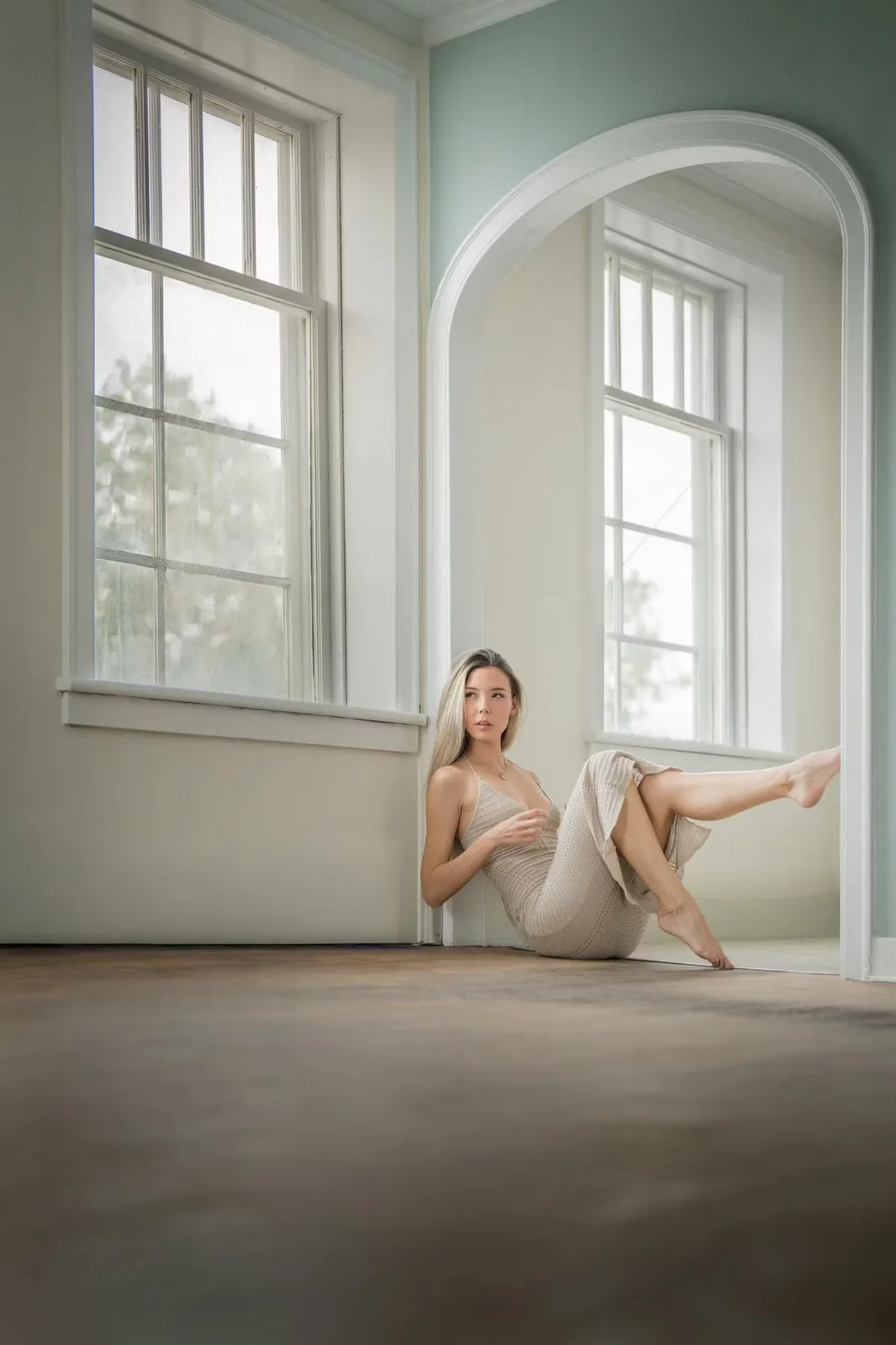 Soft natural-light portrait of a woman by an arched window